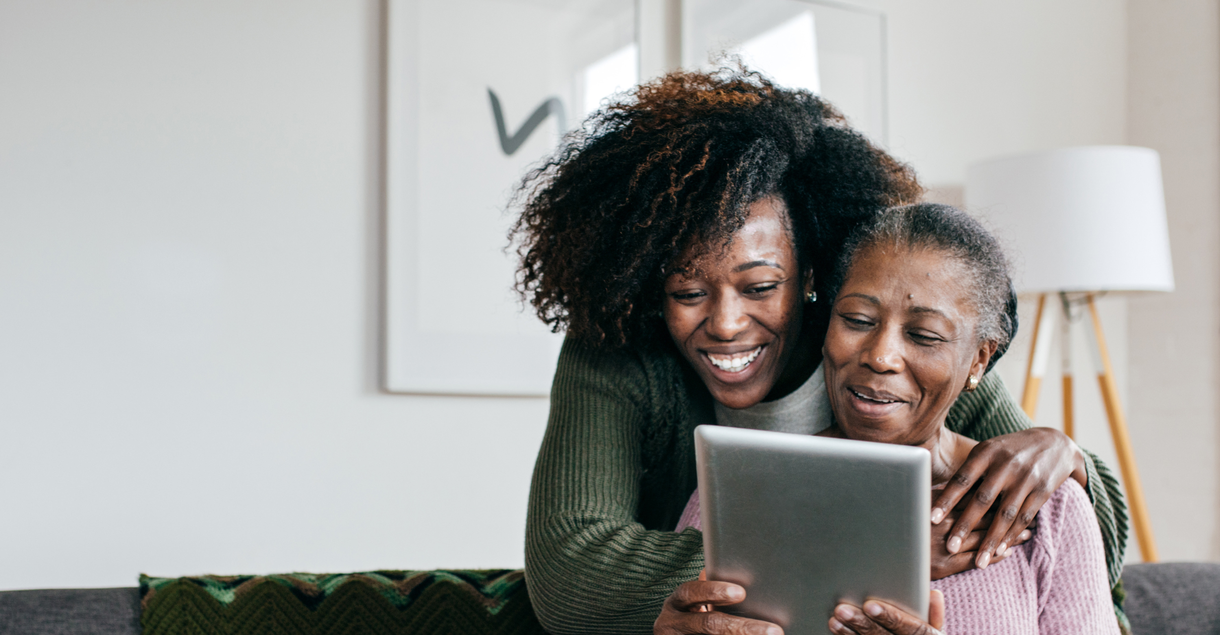 A woman reviewing Medicare plan options with her mother on a tablet